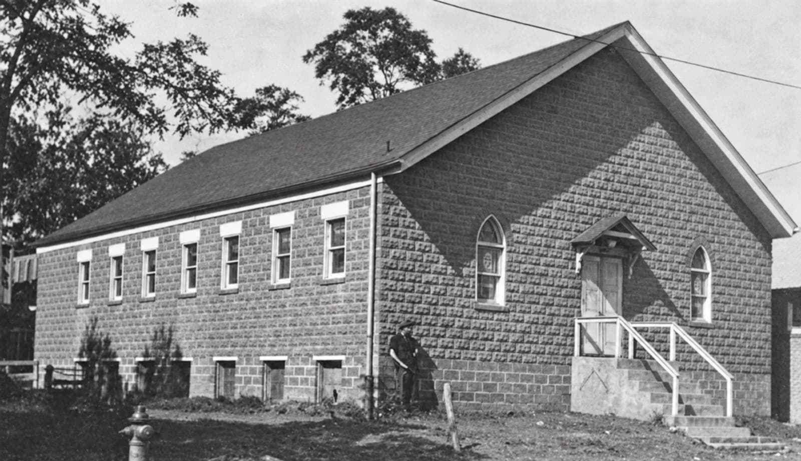 The first church at 2540 Jefferson Street, a block building with arched windows.
